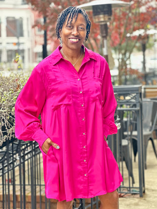 a fun magenta pink satin button down dress with long sleeves and a sleep collar