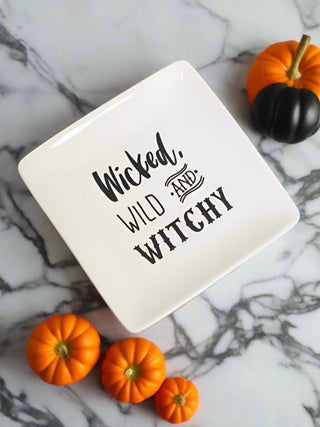 a small off white stoneware serving plate that reads wicked wild and witchy in black type perfect for halloween decor