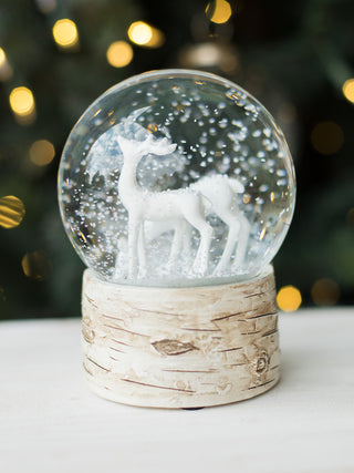 decorate your holiday home with this all white reindeer snow globe with a textured base for neutral decor