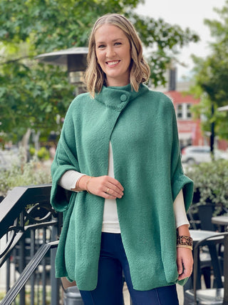 green oversized turtleneck shaw with a  one-button detail at the front