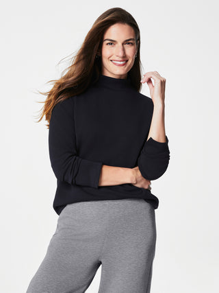 a warm spanx airessentials black pullover with long sleeves