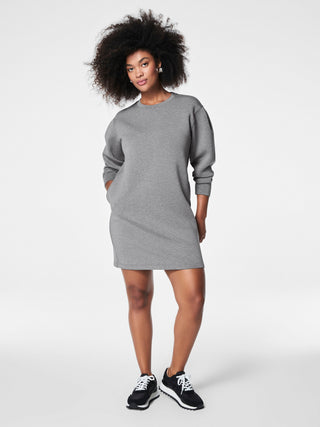 a soft trendy light fabric spanx crew neck dress in a grey color worn with black sneakers