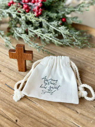 a wooden pocket cross in a gift bag that says amazing grace how sweet the sound