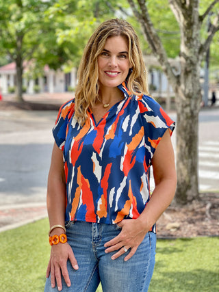 a chic navy and orange abstract blouse with ruffled collar and short raglan sleeves