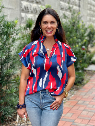 a chic red and blue abstract blouse with ruffled collar and short raglan sleeves