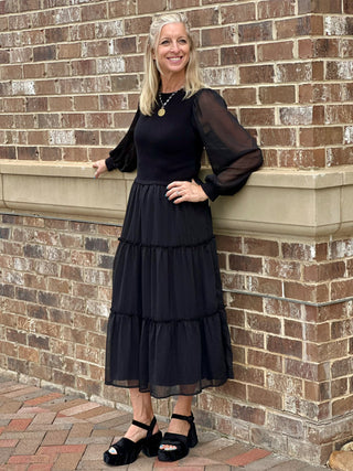 a fun black mixed media midi dress with a cozy sweater top and ruffled skirt