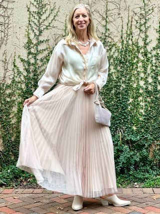 a breezy pleated beige tulle maxi skirt with a comfortable design worn with a beige blouse