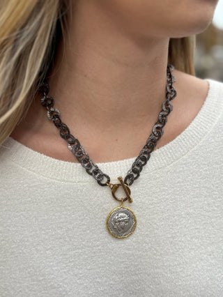 a gunmetal washer chain necklace with a vintage silver coin pendant and front clasp