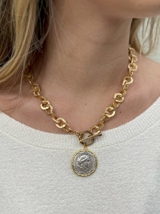 a gold washer chain necklace with a vintage coin pendant and front clasp