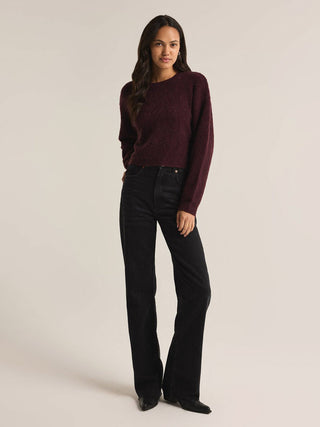 a classic plush cropped sweater in berry wine red worn with black pants