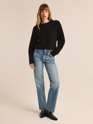 a classic plush cropped sweater in black worn with jeans