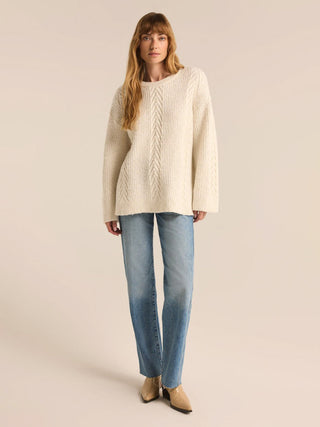 a cozy and chic champagne cream cable knit sweater worn with jeans