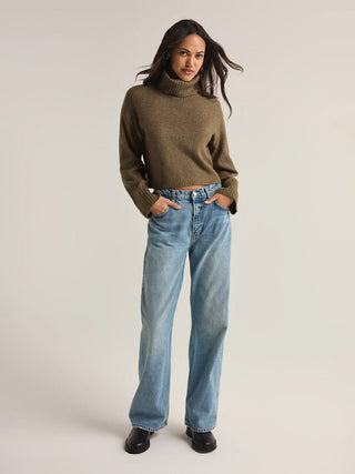 martini green colored long sleeve turtleneck sweater with ribbed detailing paired with light blue denim jeans