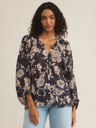 a flowy purple and cream floral print blouse with front buttons and long billowy sleeves